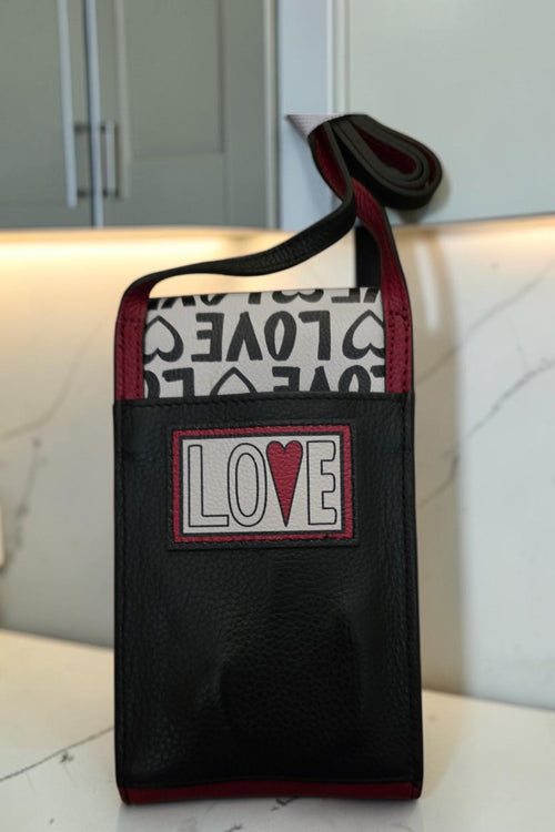 The Gettin Place Brighton Look of Love crossbody phone organizer in black, white, and red with heart appliqué.