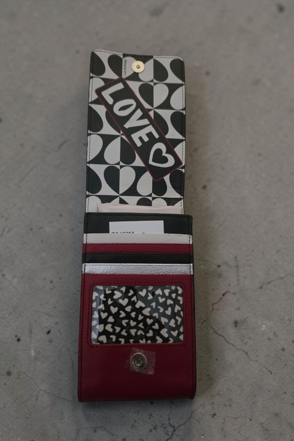 The Gettin Place Brighton Look of Love phone organizer crossbody bag with black, white, and red heart-patterned interior