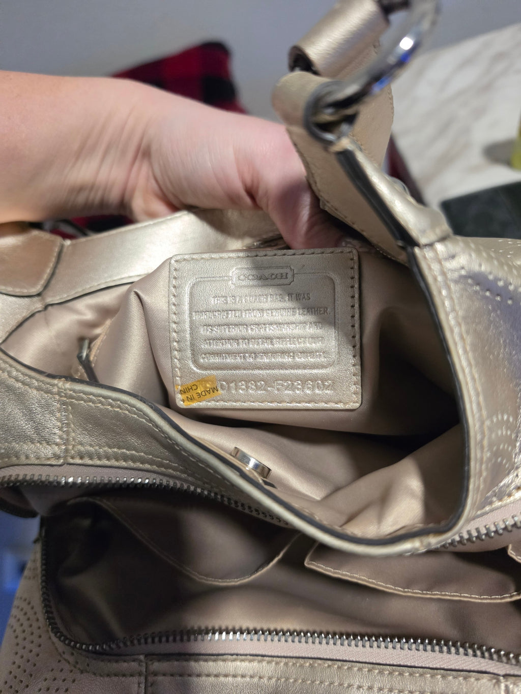 The Gettin Place Coach metallic gold leather hobo bag interior with signature creed patch and fabric lining