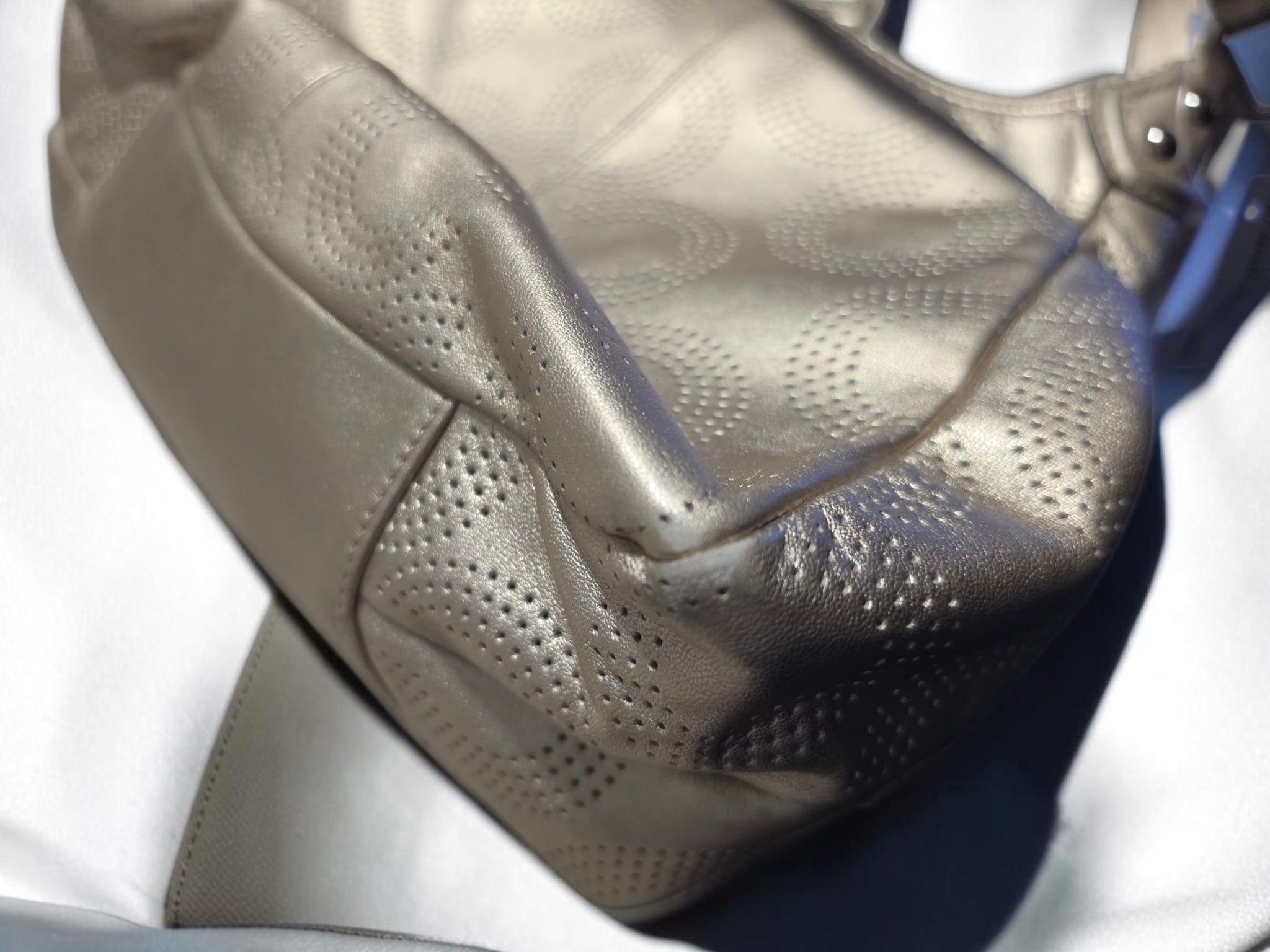 The Gettin Place Coach metallic gold leather hobo bag featuring a detailed perforated signature pattern