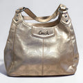 The Gettin Place Coach metallic gold leather hobo bag with perforated signature pattern and silver-tone hardware.