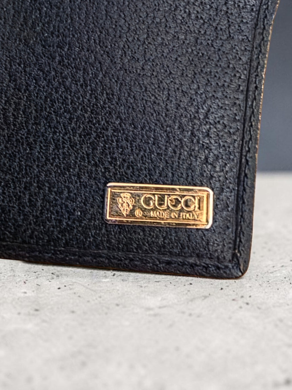 The Gettin Place vintage Gucci bifold wallet featuring navy leather and a gold-tone Gucci Made in Italy metal plaque.