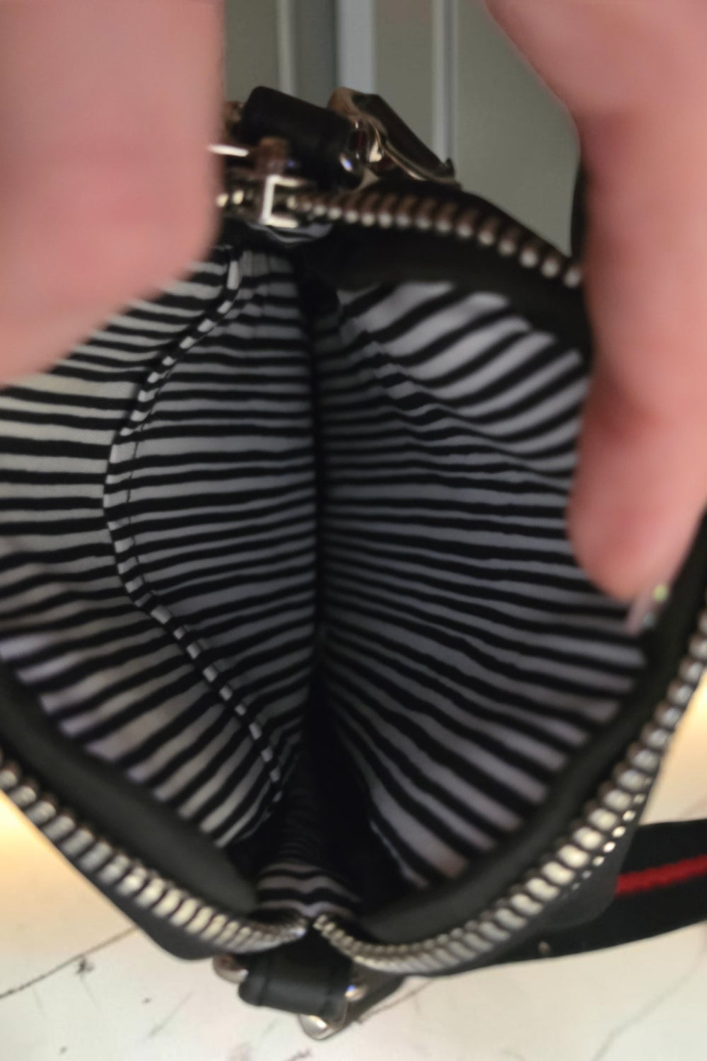 The Gettin Place Brighton crossbody bag interior featuring black and white striped lining and zippered compartment